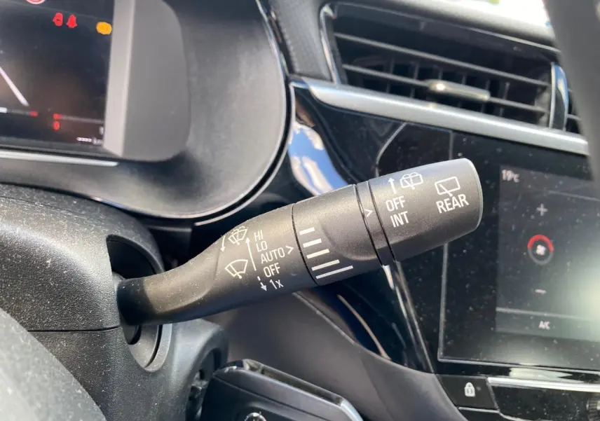 Le commodo d'essuie-glace en gros plan dans l'habitacle noir de l'Opel Corsa bleu nautique 2021.