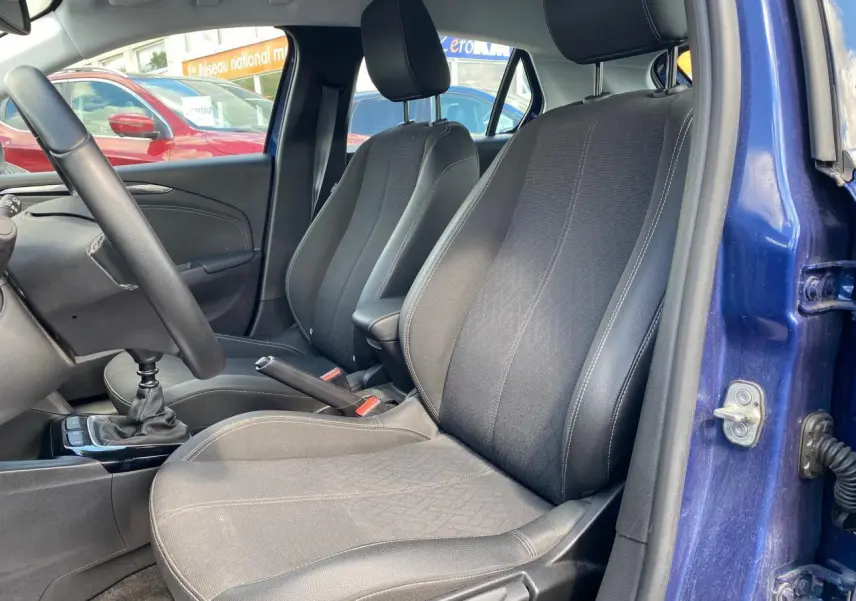 Vue intérieure côté conducteur de l'Opel Corsa bleu nautique 2021, sièges tissu noir et volant cuir multifonction.