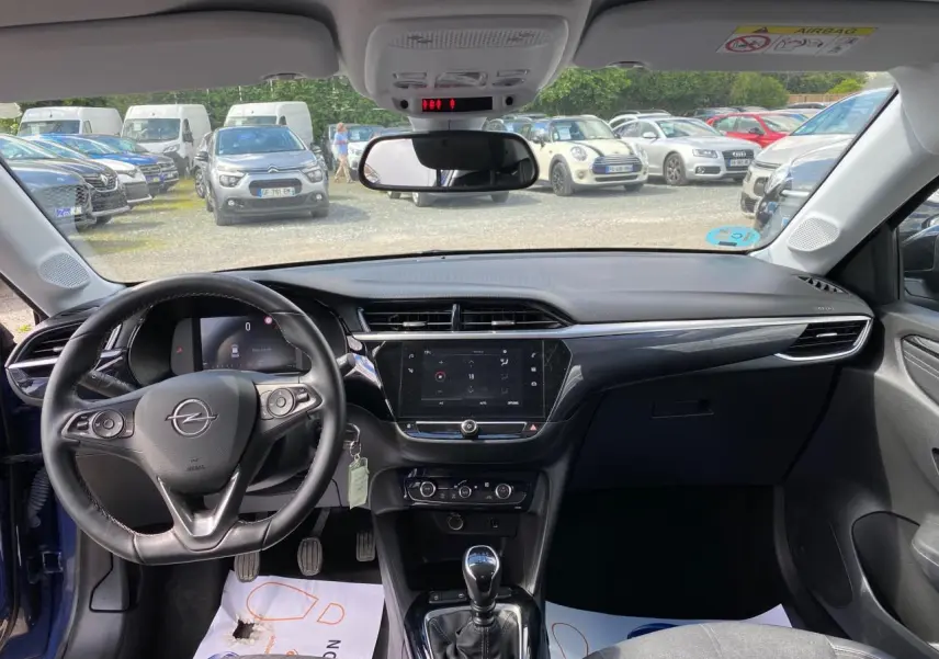 Vue intérieure avant de l'Opel Corsa bleu nautique 2021, tableau de bord avec écran tactile et volant cuir multifonction.
