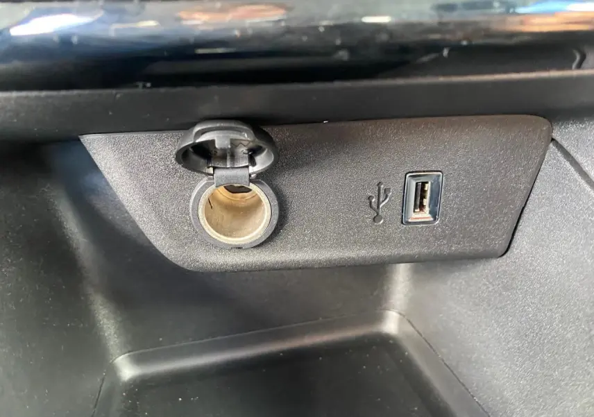 Prise 12V et port USB type-A intégrés dans la console centrale de l'Opel Corsa 1.2i Turbo bleu nautique.