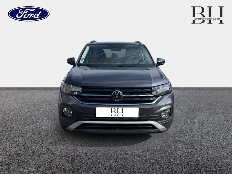Volkswagen T-Cross gris cendré métallisé vu de face avec calandre noire et détails chromés.