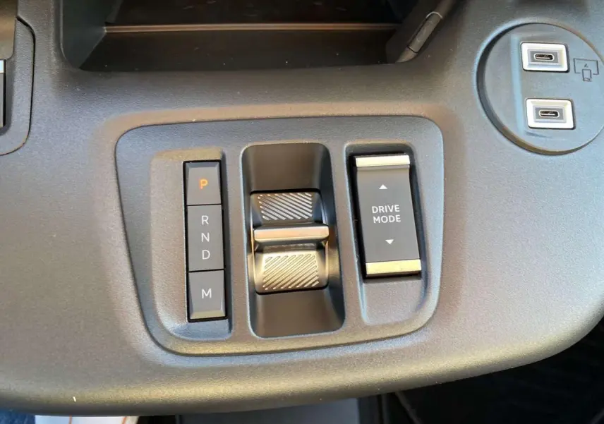 Gros plan sur la console centrale du Citroën Berlingo 2025 montrant la commande de boîte automatique et le bouton Drive Mode.