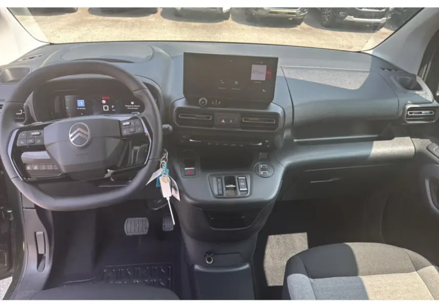 Vue intérieure du tableau de bord du Citroën Berlingo 2025, avec volant multifonction et écran tactile central.