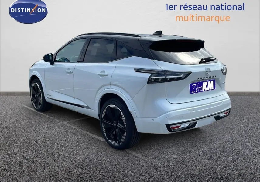Vue 3/4 arrière droite du Nissan Qashqai blanc nacré avec toit noir, jantes noires et feux arrière LED distinctifs.