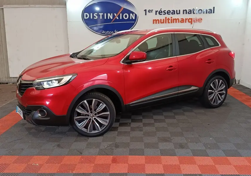 Renault Kadjar rouge vue de profil côté gauche dans un showroom avec jantes alliage et feux allumés.