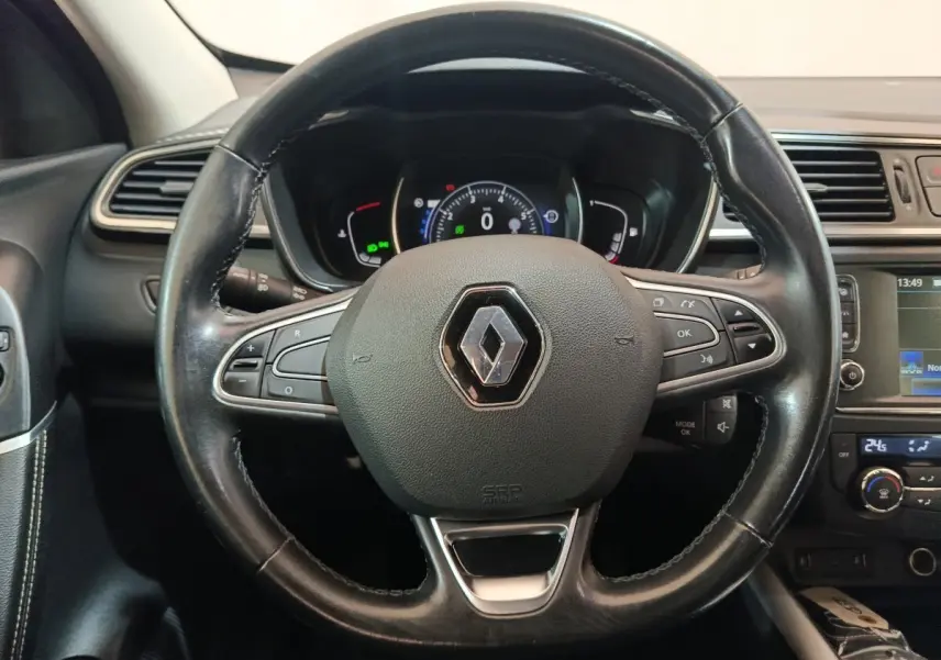 Volant cuir noir avec logo Renault au centre, tableau de bord numérique et écran tactile du Renault Kadjar Intens rouge 2017.