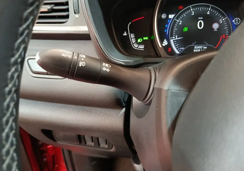 Gros plan sur le commodo d'éclairage à gauche du volant cuir du tableau de bord du Renault Kadjar rouge 2017.