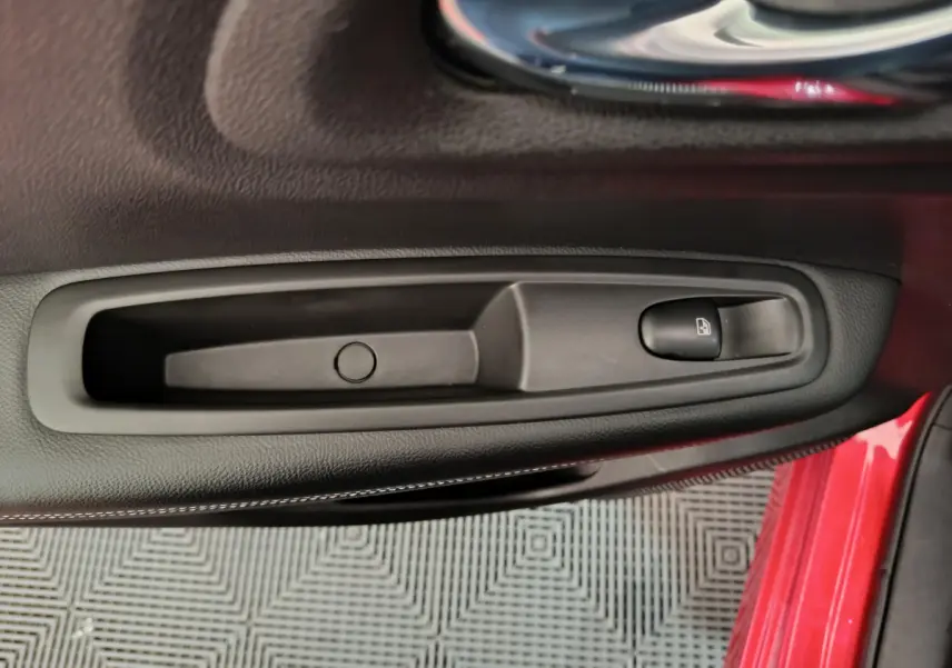 Poignée intérieure noire avec bouton de verrouillage sur la porte côté conducteur du Renault Kadjar rouge 2017.