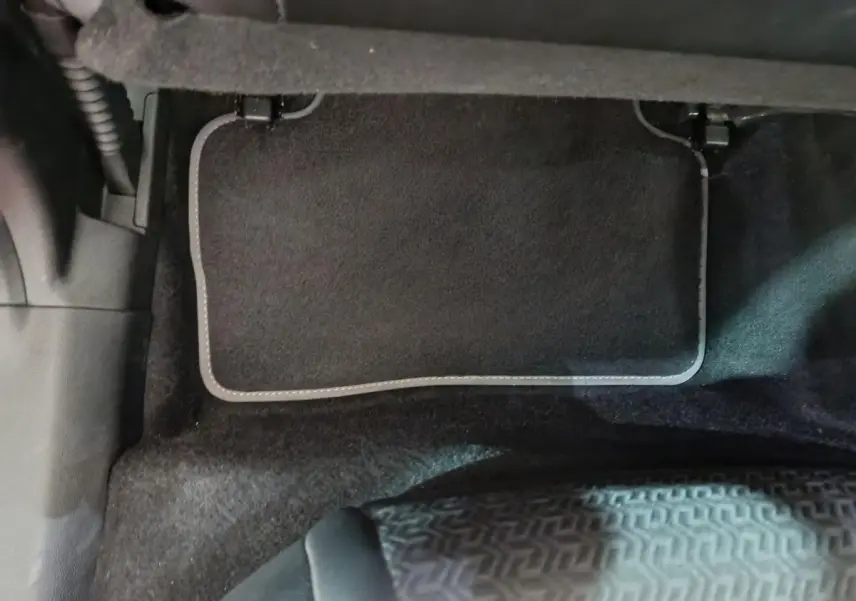 Tapis de sol noir côté conducteur du Renault Kadjar Intens rouge, vue rapprochée de l'intérieur au sol.