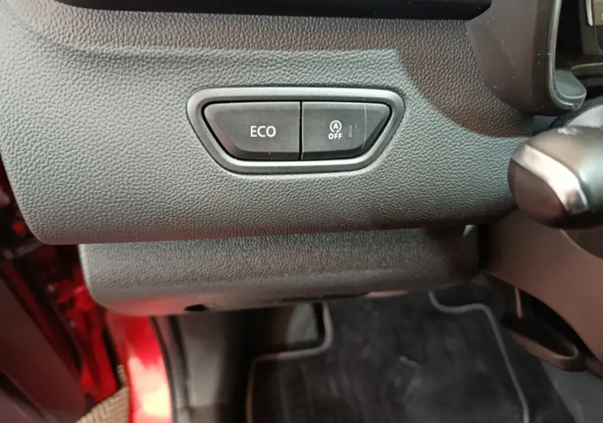 Gros plan sur les boutons ECO et arrêt du démarrage automatique dans l'habitacle du Renault Kadjar rouge 2017.