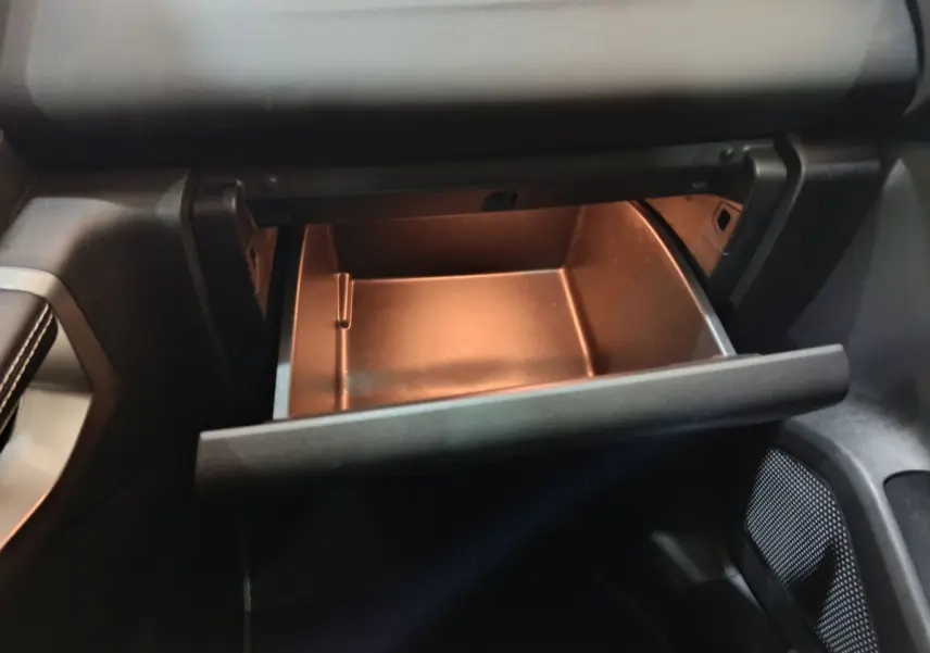 Gros plan sur la boîte à gants ouverte côté passager du Renault Kadjar Intens rouge de 2017.