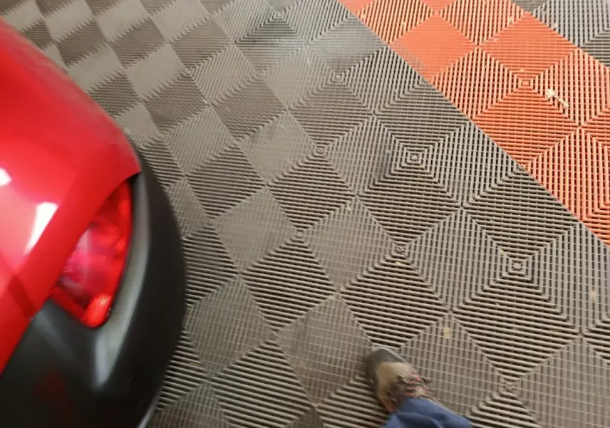 Gros plan sur le coin arrière gauche rouge du Renault Kadjar Intens avec feu arrière et partie du pare-chocs noir.