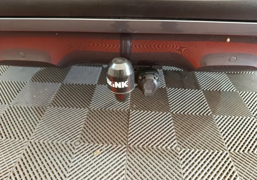 Gros plan sur l'attelage de remorque noir fixé sous le pare-chocs arrière rouge du Renault Kadjar Intens 2017.