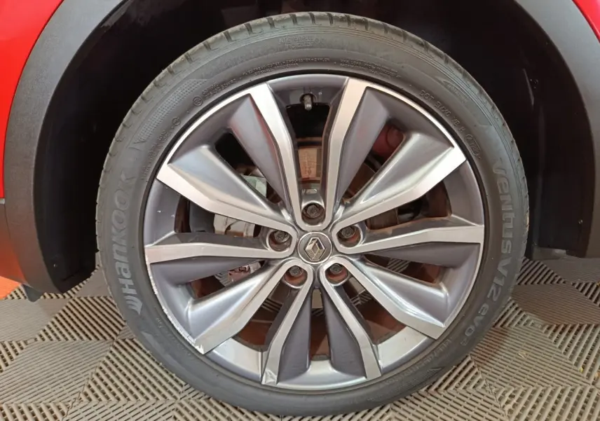 Gros plan sur la roue avant droite du Renault Kadjar rouge, mettant en valeur la jante alliage et le logo central.