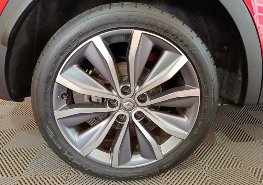Gros plan sur la roue avant droite du Renault Kadjar rouge, mettant en valeur la jante alliage et le pneu Dunlop.