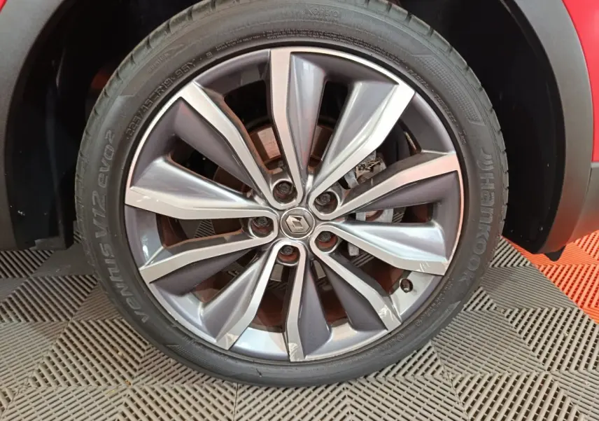 Gros plan sur la roue avant droite du Renault Kadjar rouge, avec jante alliage au design moderne et logo central Renault.