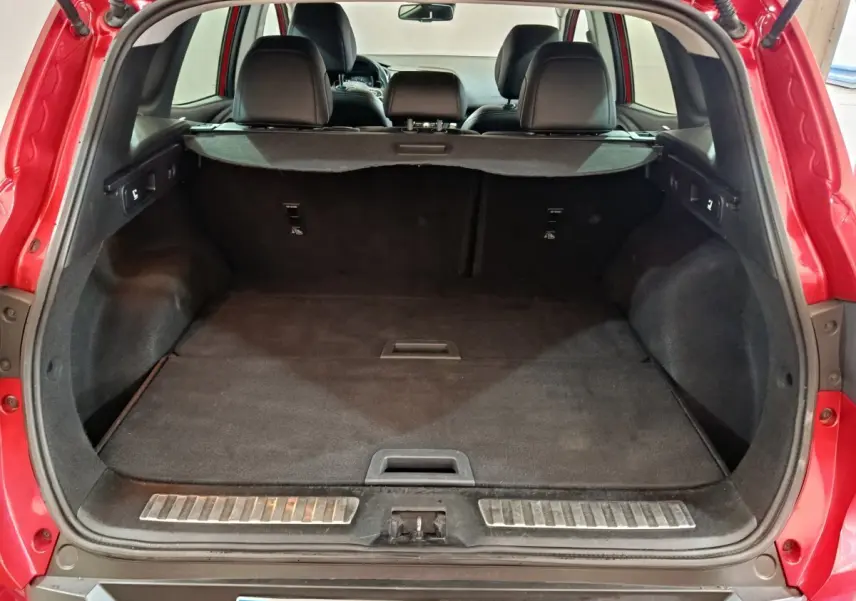 Vue arrière du coffre spacieux d'un Renault Kadjar Intens rouge de 2017 avec banquette noire rabattue et tablette de séparation.