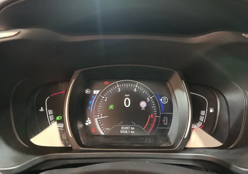 Vue rapprochée du tableau de bord numérique du Renault Kadjar rouge, affichant la vitesse à zéro et les indicateurs actifs.