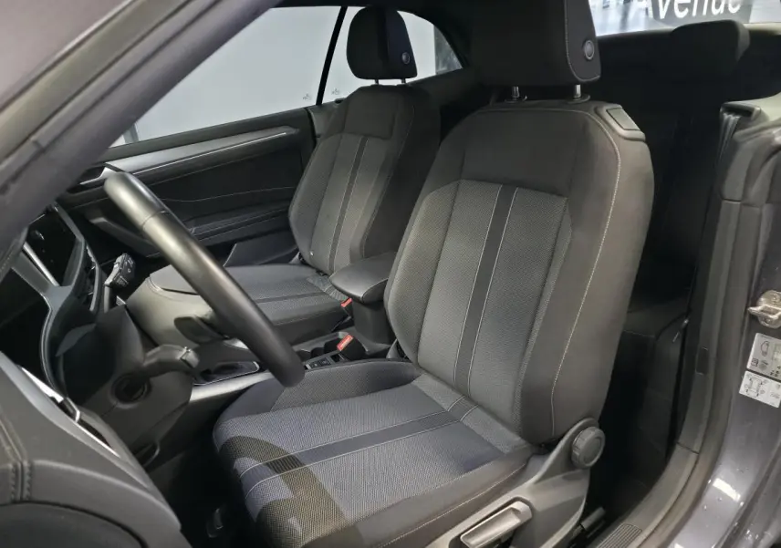 Intérieur du Volkswagen T-Roc Cabriolet gris 2024, vue côté conducteur sur les sièges avant en tissu noir et gris.