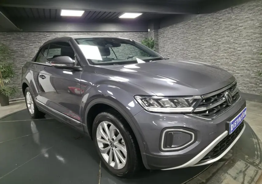 Volkswagen T-Roc Cabriolet gris métallisé vue 3/4 avant droit avec calandre chromée et jantes alliage.