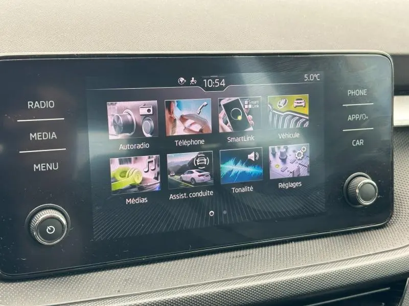 Écran tactile central du tableau de bord de la Skoda Fabia 2024 affichant les menus multimédia et assistance conduite.