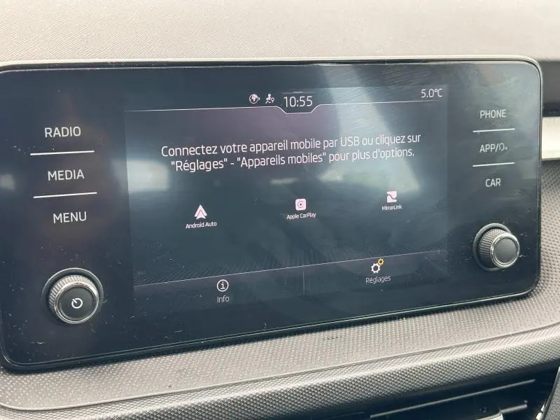 Écran tactile central de la Skoda Fabia 2024 affichant la connexion mobile avec commandes physiques de chaque côté.