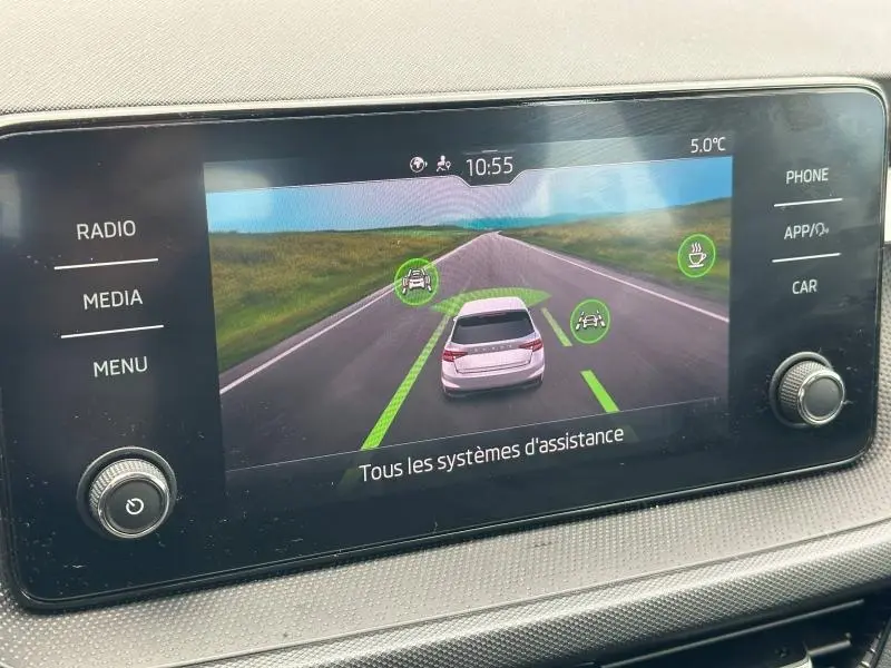 Écran tactile intérieur montrant l'assistance à la conduite d'une Skoda Fabia 2024, vue arrière virtuelle du véhicule.
