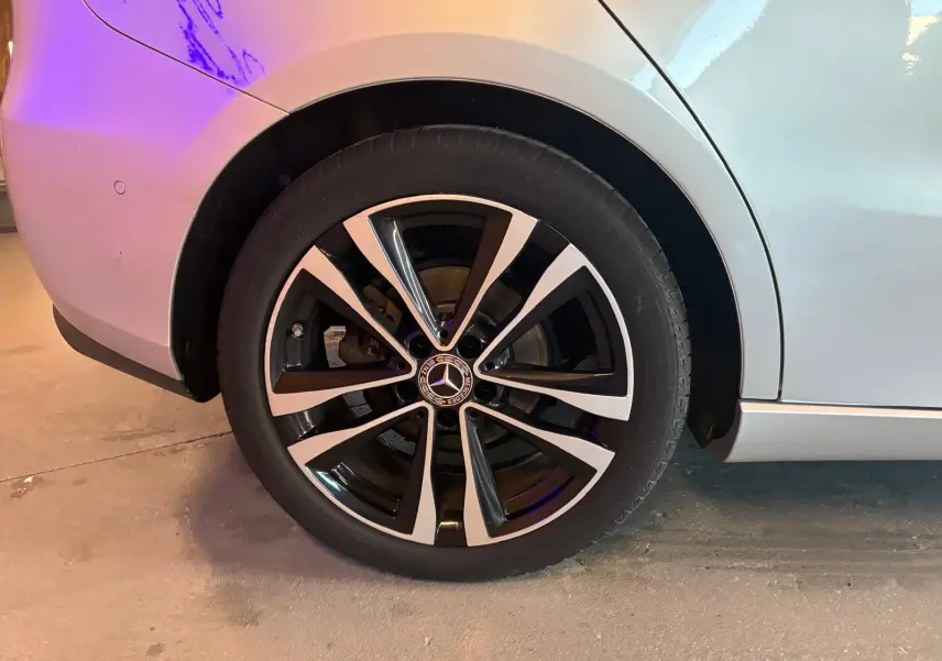Gros plan sur la roue arrière droite d’une Mercedes Classe B 200D gris métallisé avec jante alliage noire et argent.