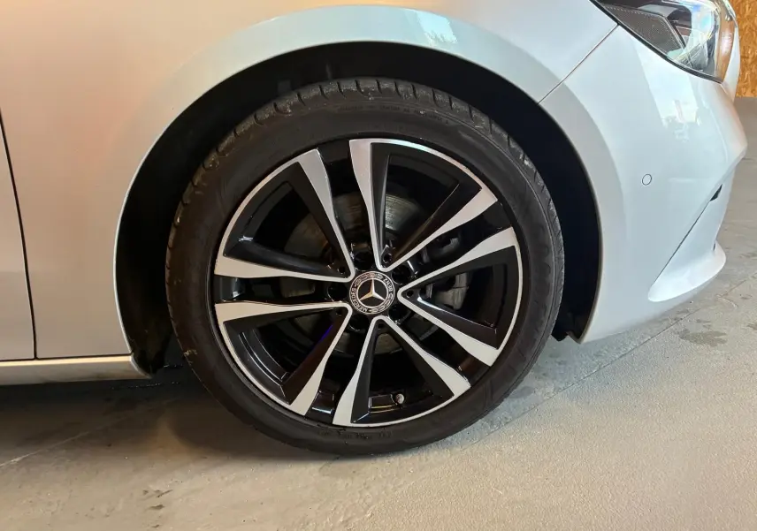 Gros plan sur la roue avant droite gris clair d'une Mercedes Classe B 200D Progressive Line avec jante alliage noir et argent.