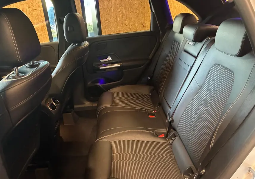 Vue intérieure arrière côté droit de la Mercedes Classe B 200D Progressive Line avec sièges tissu gris noir et appuie-têtes.