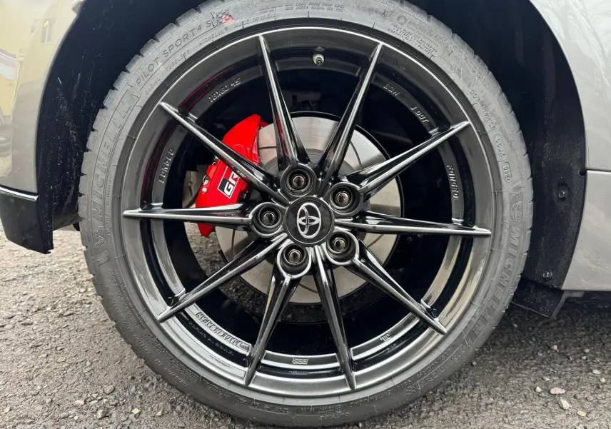 Gros plan sur la jante BBS forgée noire et l'étrier de frein rouge GR de la Toyota Yaris Gris Platine côté arrière.