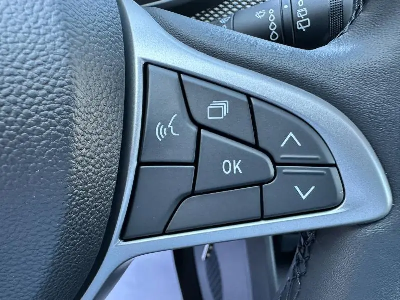 Gros plan sur les commandes noires du volant côté droit de la Dacia Sandero beige Safari 2025 Stepway.