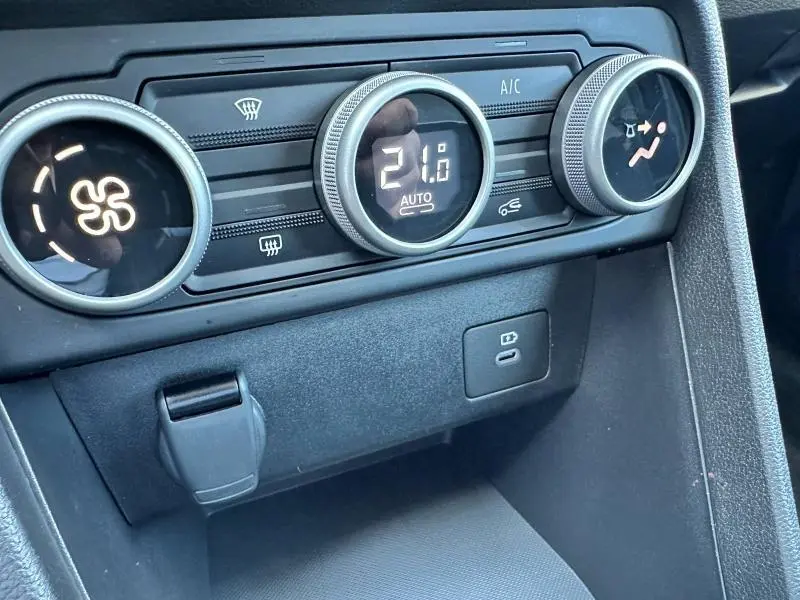 Gros plan sur les commandes de climatisation digitale et prises USB d'une Dacia Sandero beige Safari 2025 Stepway.