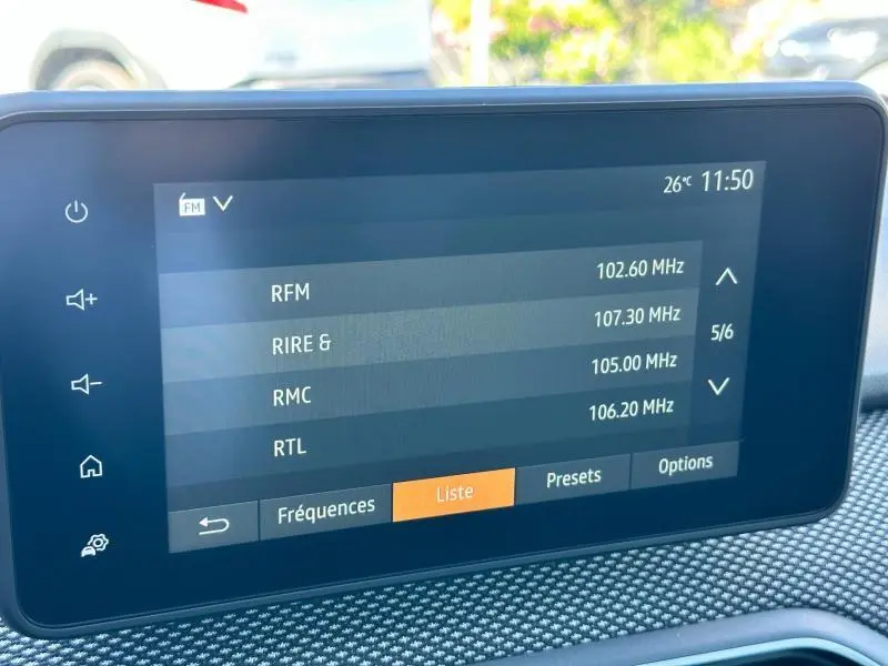 Écran tactile central affichant la liste des stations radio dans l'habitacle du Dacia Sandero beige Safari 2025.