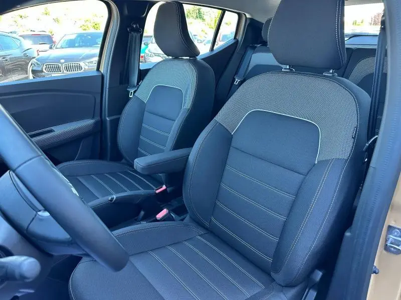Vue intérieure côté gauche montrant les sièges avant en tissu Stepway noir avec surpiqûres, dans une Dacia Sandero beige Safari.