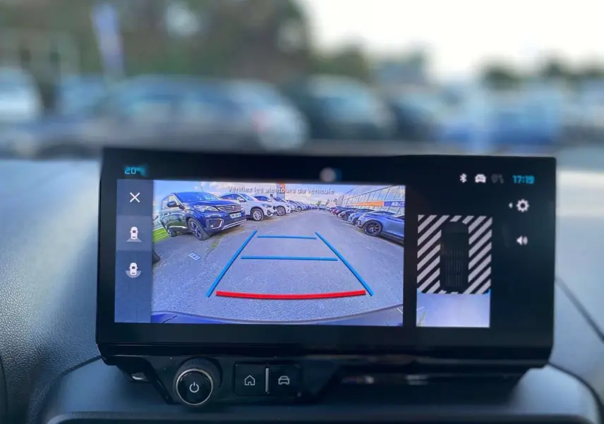 Écran tactile intérieur montrant la caméra de recul avec vue arrière et lignes de guidage du Citroën Berlingo bleu 2025.
