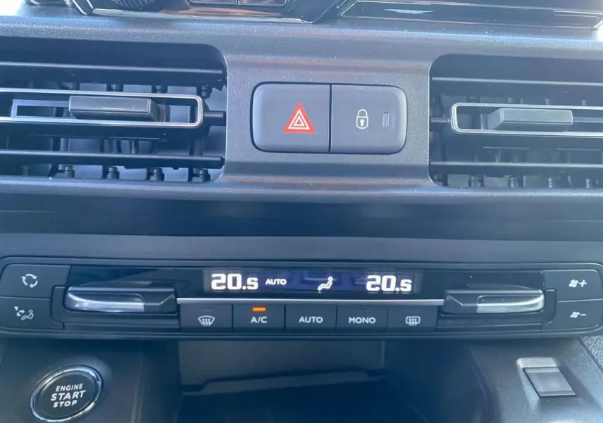 Détail du tableau de bord du Citroën Berlingo 2025 bleu, montrant la climatisation automatique bi-zone et le bouton start/stop.