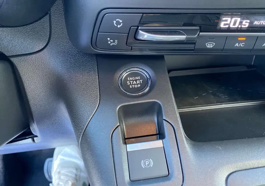 Détail du bouton start/stop et frein électrique sur la console centrale noire du Citroën Berlingo 2025.