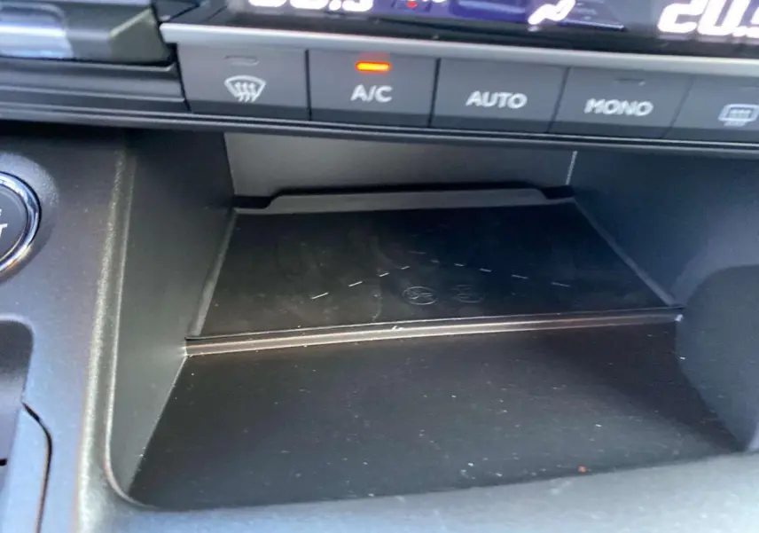 Gros plan sur la console centrale noire du Citroën Berlingo 2025, avec commandes climatisation et zone de rangement.