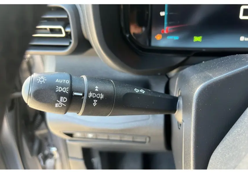 Gros plan sur la commande des feux et clignotants du tableau de bord du Citroën Berlingo bleu 2025.