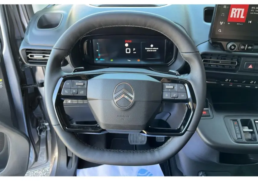 Vue rapprochée du volant cuir noir du Citroën Berlingo 2025 avec commandes intégrées et combiné numérique.
