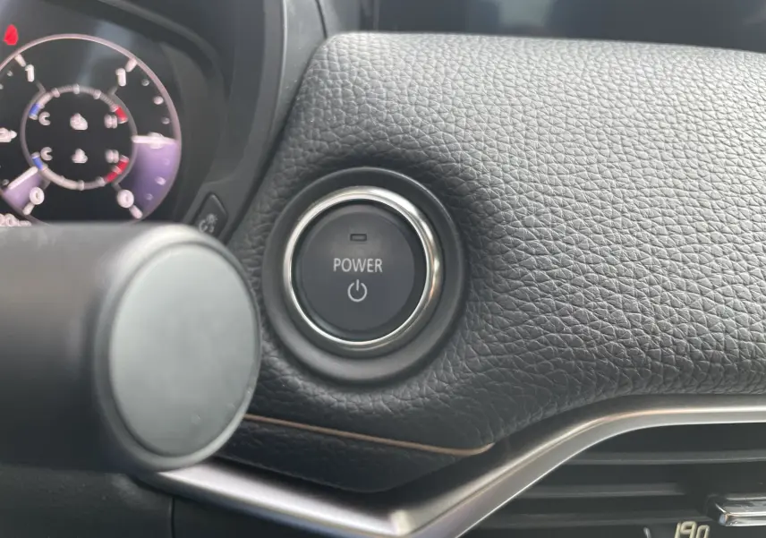 Gros plan sur le bouton Power entouré de cuir noir texturé dans le tableau de bord du Mazda CX-60 hybride 2023.