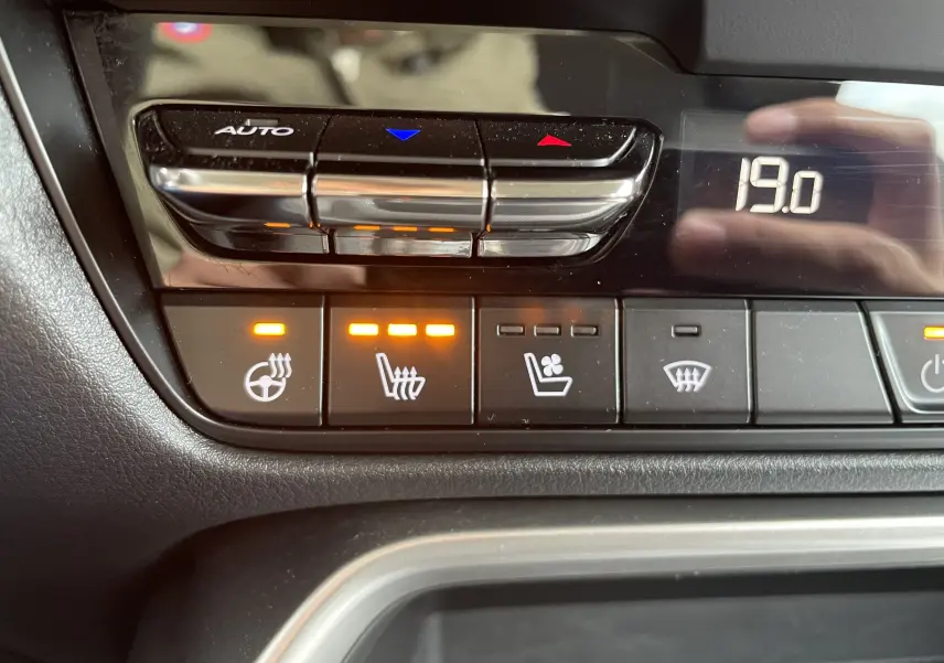 Gros plan sur les commandes de climatisation et sièges chauffants du Mazda CX-60 blanc nacré, affichant 19°C.