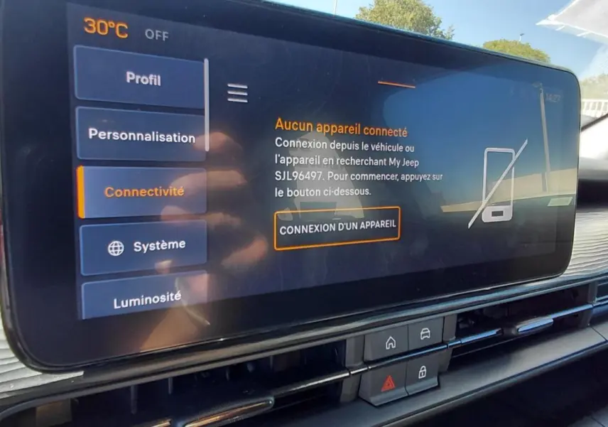 Écran tactile central du Jeep Avenger 2025 blanc, affichant le menu connectivité avec haut-parleur JBL visible.