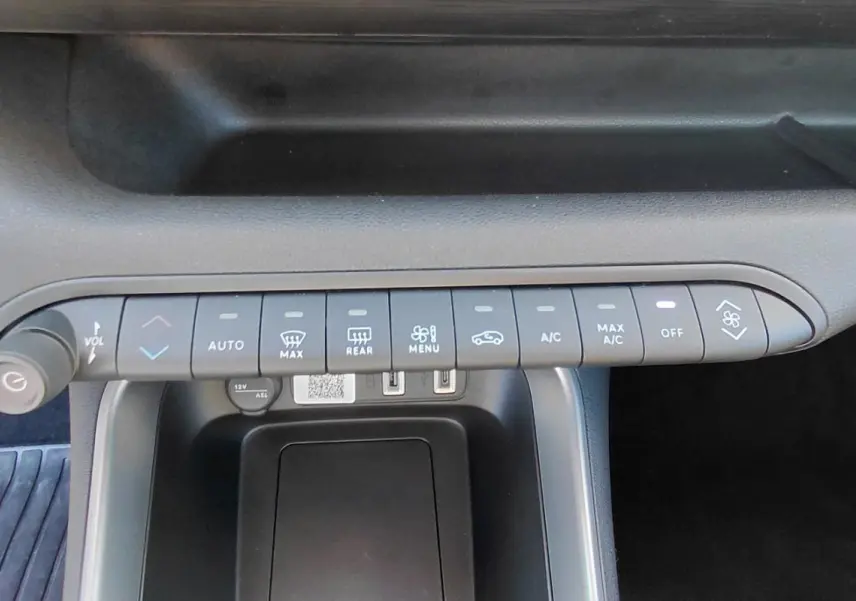 Vue rapprochée de la console centrale du Jeep Avenger blanc 2025, montrant les commandes de climatisation et le bouton start/stop.