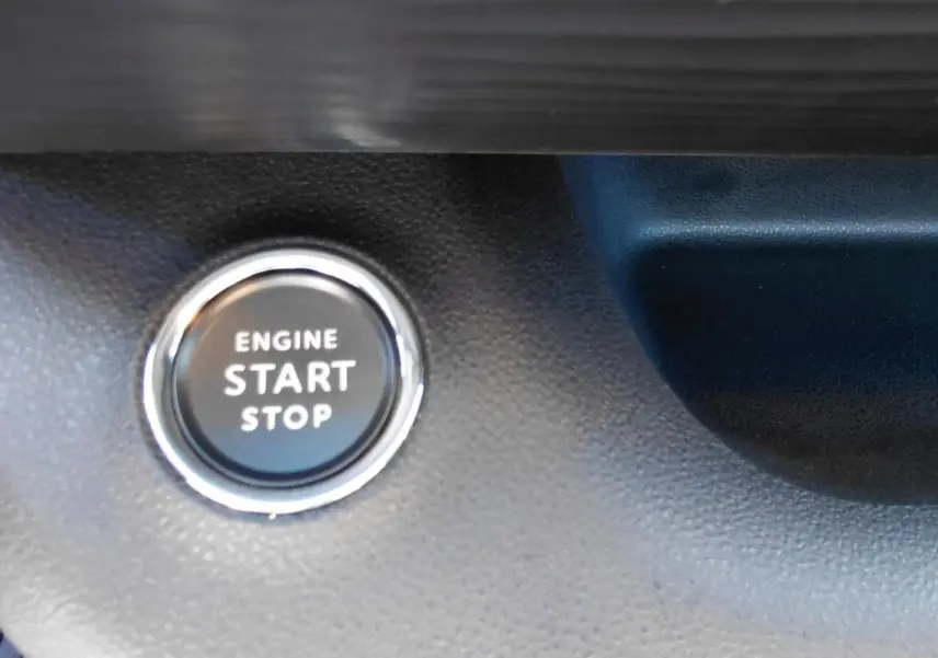 Bouton moteur start/stop en gros plan sur tableau de bord noir du Jeep Avenger blanc 2025, version Altitude.