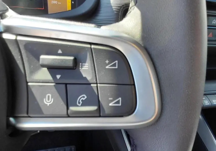 Gros plan sur les commandes au volant côté gauche du Jeep Avenger blanc 2025, avec boutons de volume et appels.