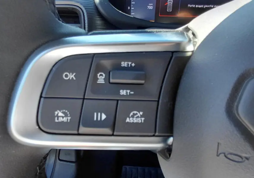 Gros plan sur les commandes de régulateur de vitesse au volant du Jeep Avenger blanc 2025, version Altitude.