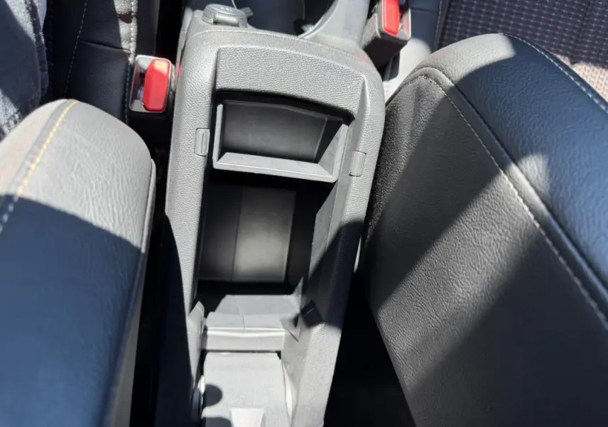 Vue plongeante sur la console centrale grise ouverte du DS3 100 BVM6 Performance Line 2024, avec accoudoirs en cuir noir.