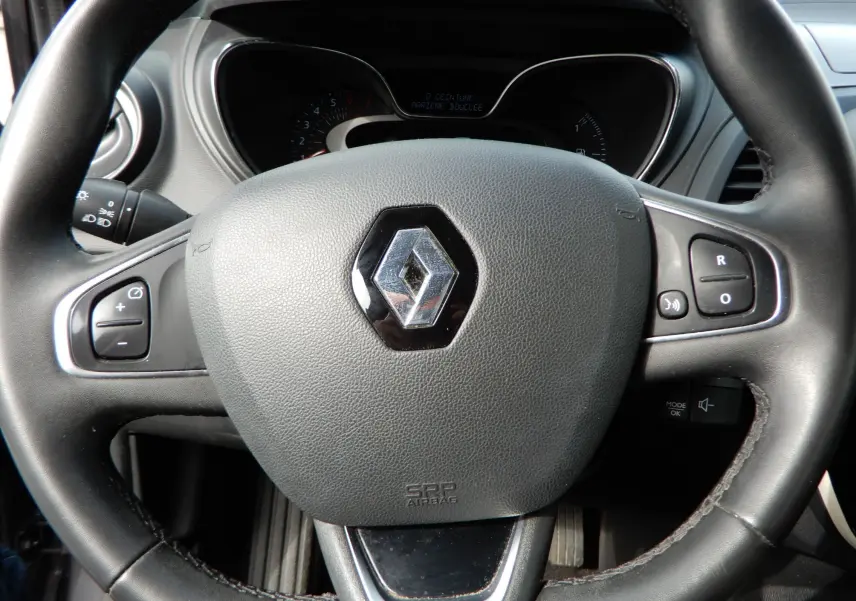 Vue rapprochée du volant gris du Renault Captur TCE 90 Business 2019 avec commandes intégrées et logo central.